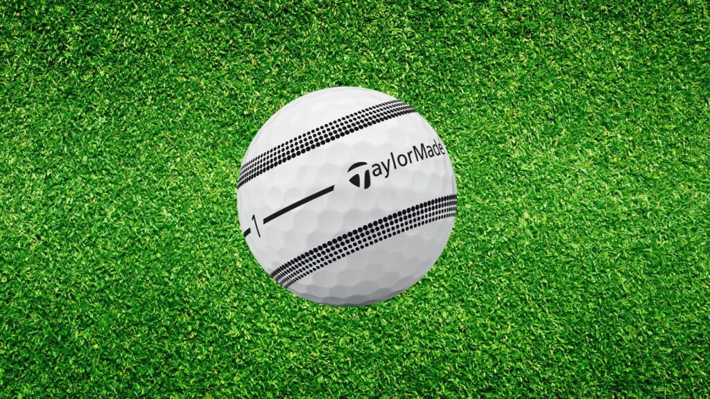Balle de golf TaylorMade TP5 Stripe posée sur herbe verte, vue du design et motif d'alignement