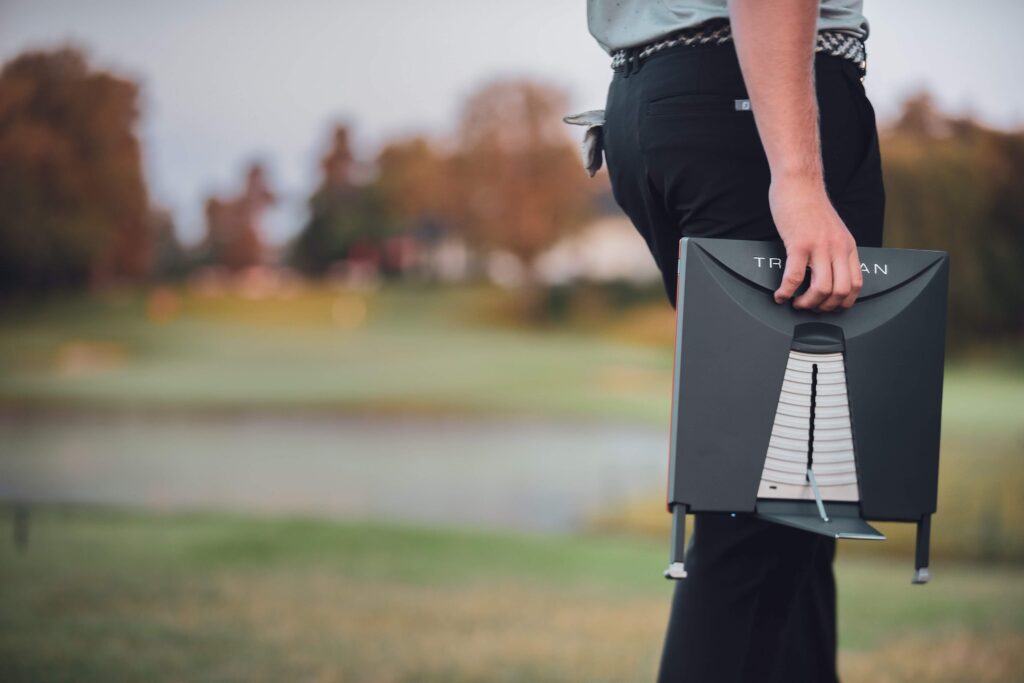 golfeur-transport-radar-trackman Golfeur transportant un radar TrackMan portable sur un parcours de golf.