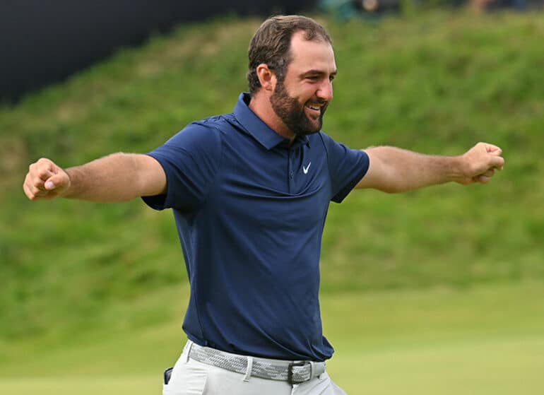 Scottie Scheffler lève les bras après une victoire au golf en 2025.
