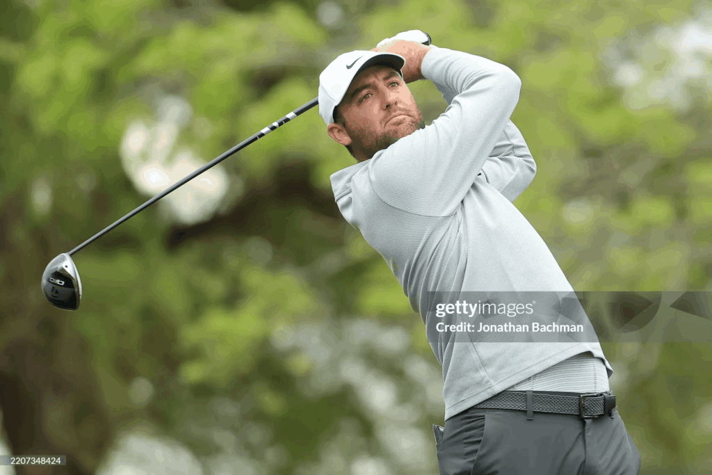 Scottie Scheffler exécute un swing de golf avec un driver sur le parcours.